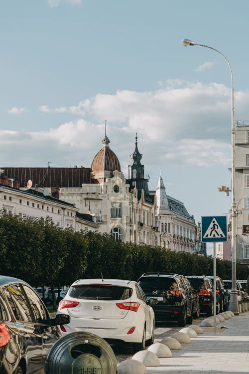 Free A picturesque street scene in Lviv, showcasing historic architecture and parked cars under a clear sky. Stock Photo