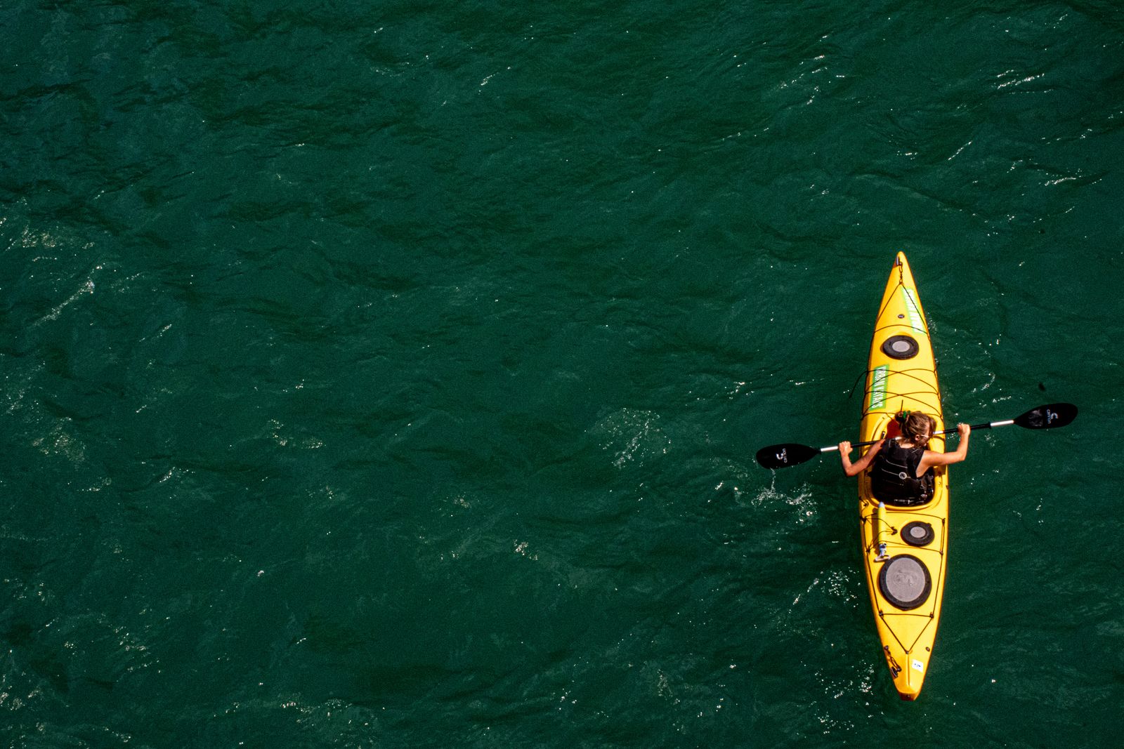 Aerial view of a yellow kayak gliding over turquoise water