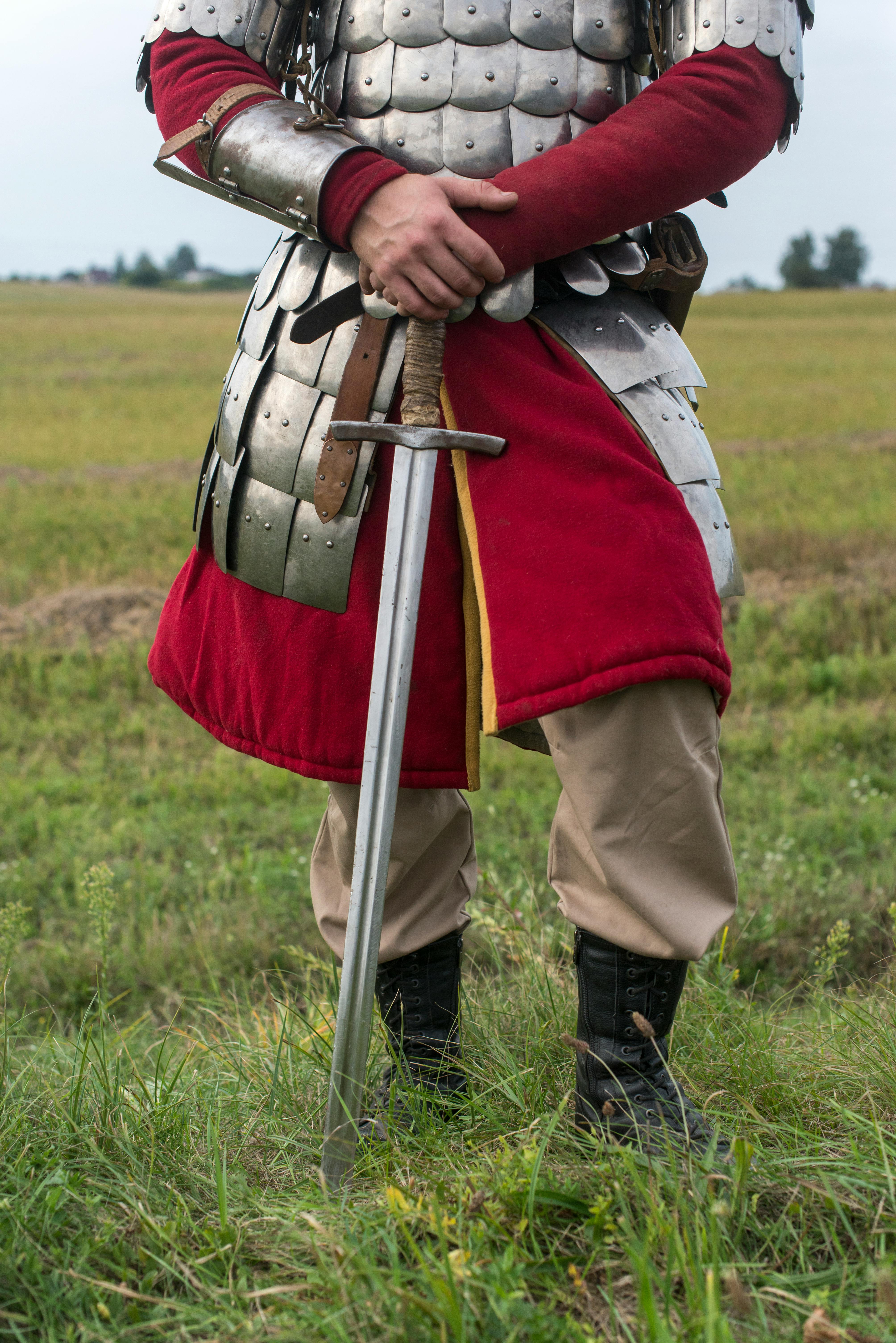 person in red and gold vest and brown pants