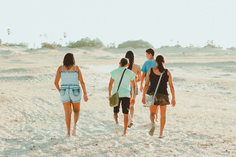 Group of friends walking through sandy landscape, enjoying outdoor adventure in Brazil.