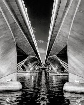 戏剧性的黑白图像展示了新加坡滨海艺术中心大桥在夜间的建筑对称性