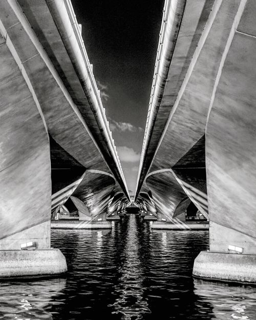Free Dramatic black and white image showcasing the architectural symmetry of Singapore's Esplanade Bridge at night. Stock Photo