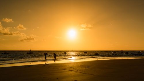 Free Golden hour at Porto de Galinhas with silhouettes against a vibrant sunset. Stock Photo