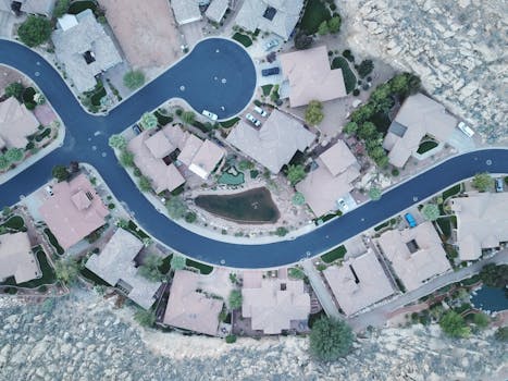 Drone aerial photo of a suburban neighborhood street layout with houses and greenery.