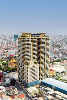 Aerial view of a modern skyscraper amidst an urban city landscape with diverse architecture.