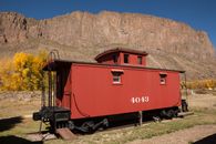 Red and Brown Train Near Brown Rocky Mountain