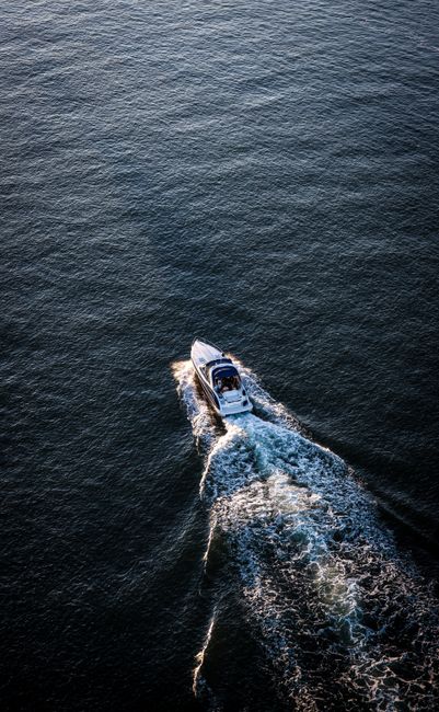Drone shot of a motorboat navigating the open sea, showcasing transportation and adventure.