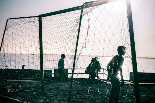 阳光明媚的海边，人们围着足球球门