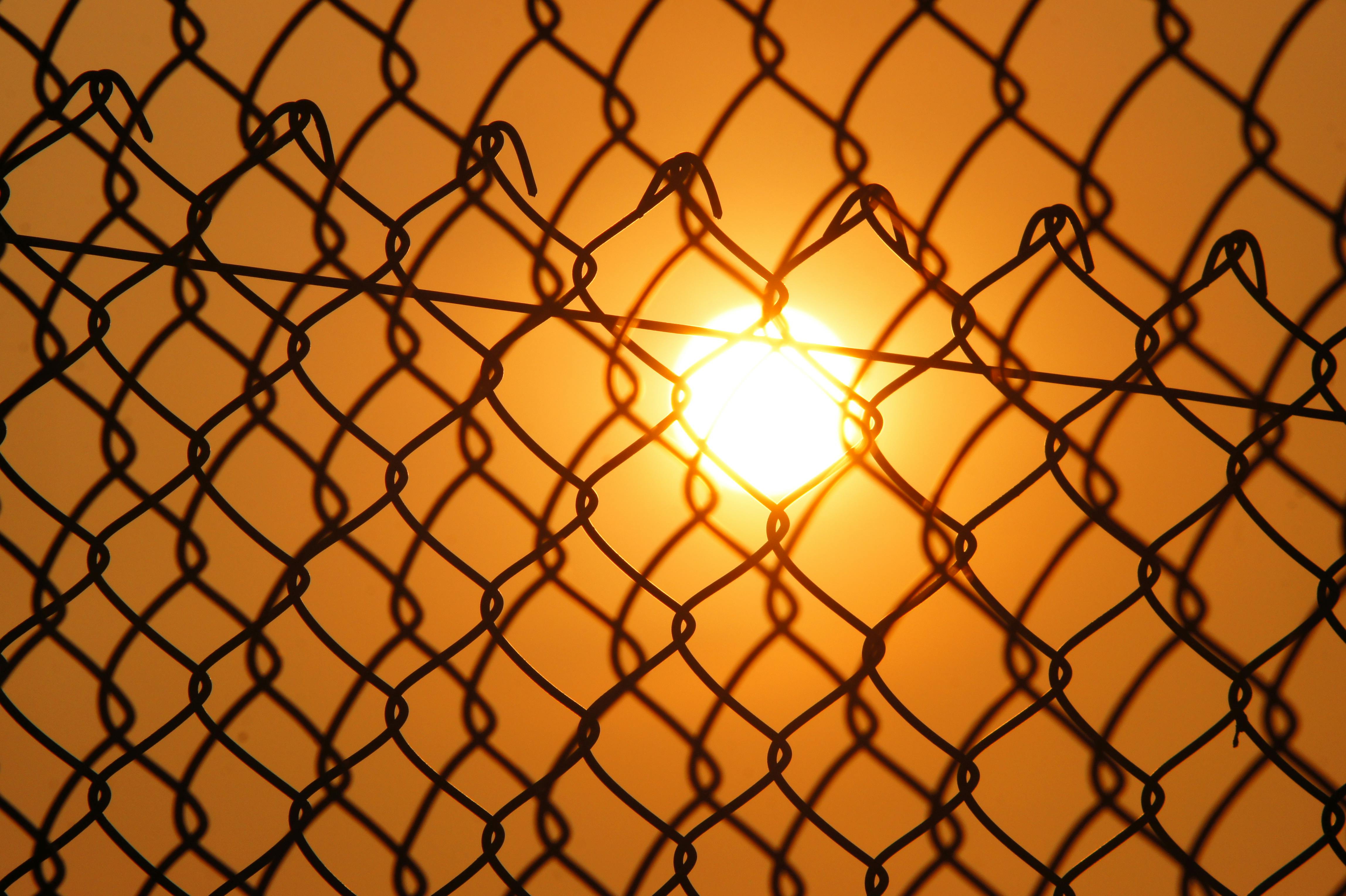 sun over the cyclone fence