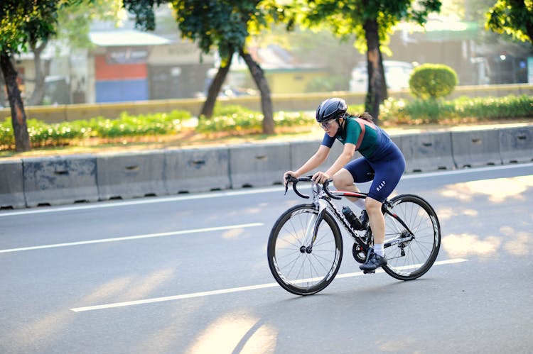 Woman Riding A Bike On Road 