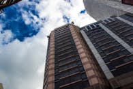 多云天空下，城市背景中现代摩天大楼的低角度拍摄