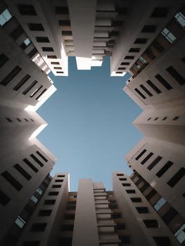 Looking up at modern high-rise buildings with clear blue sky in Bengaluru, India