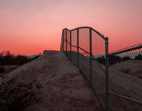 Metal Fence on Hill Under Sunset 
