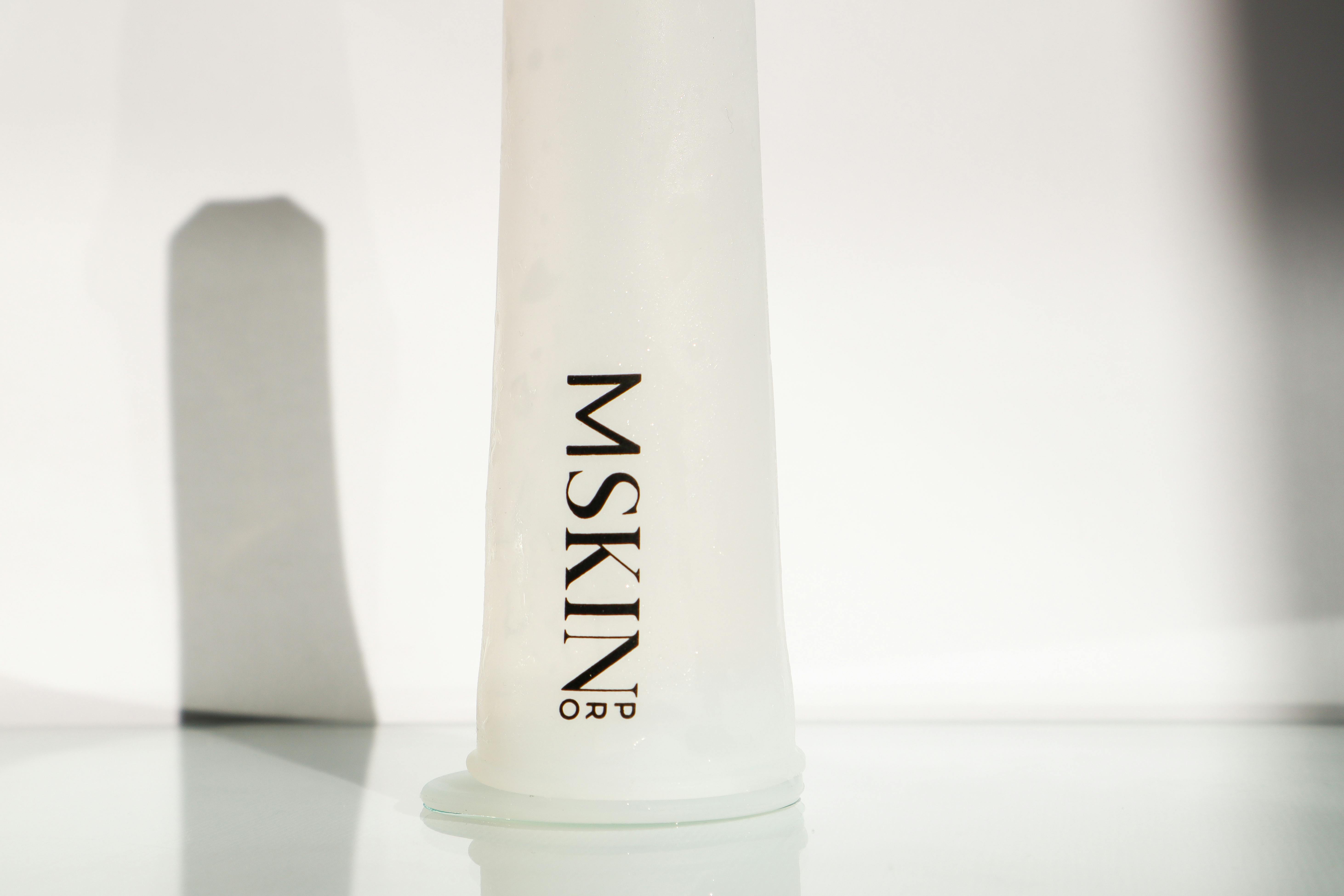 skin care product in white glass bottle