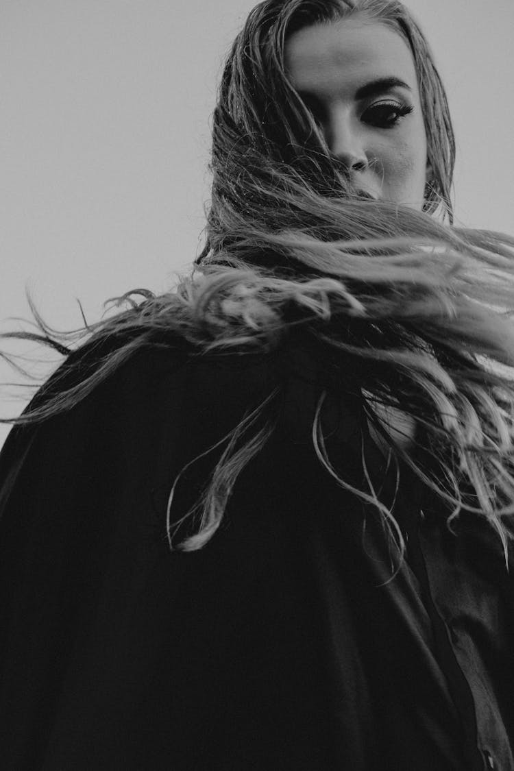 A Woman With Her Hair Flying In The Wind