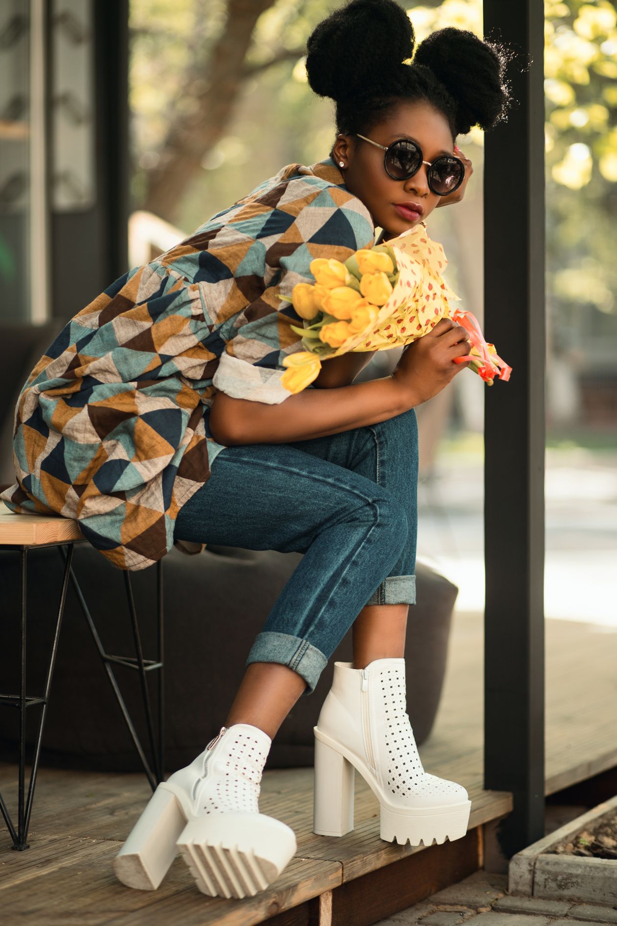 Woman in cuffed jeans wearing white perforated chunky-heeled ankle booties