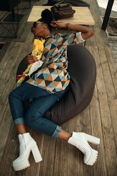 一位穿着时髦的年轻女子，在摆满鲜花的木甲板上放松地摆着姿势