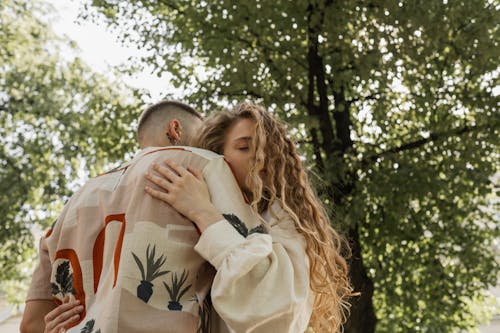 Free A Man and Woman Hugging Under a Tree Stock Photo