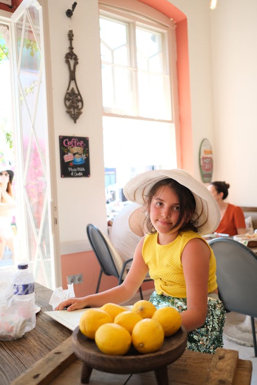 Girl Wearing Sunhat Sitting Inside Coffee Shop