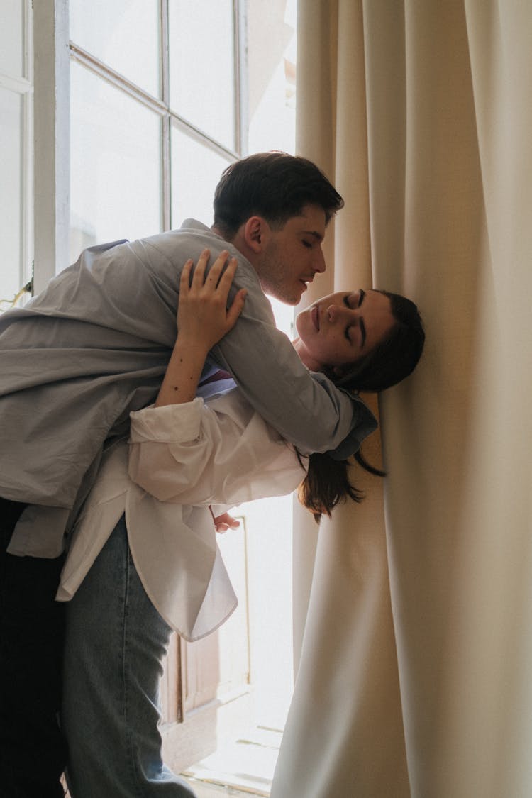 Man Holding A Woman Near Curtain