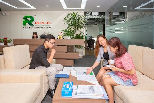 A Consultant Sitting at a Table and Talking to a Man and Woman in an Office 