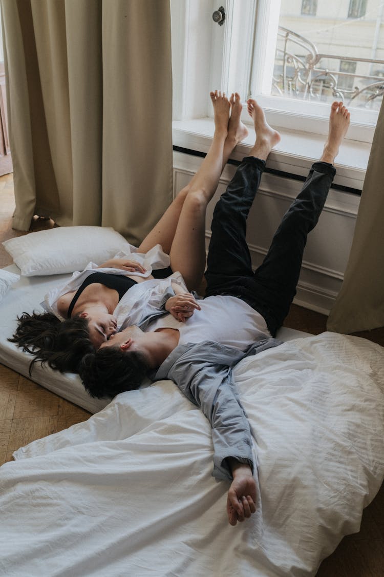 Couple Lying On Bed While Facing Each Other