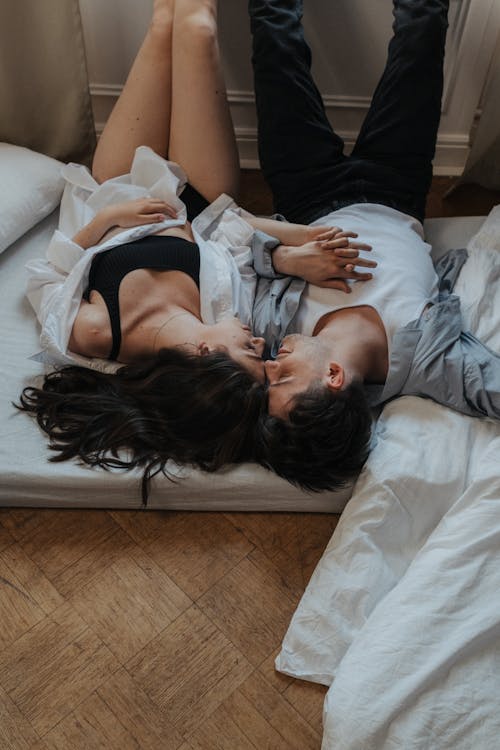 Free A Couple Lying Down on the Mattress on the Floor Stock Photo