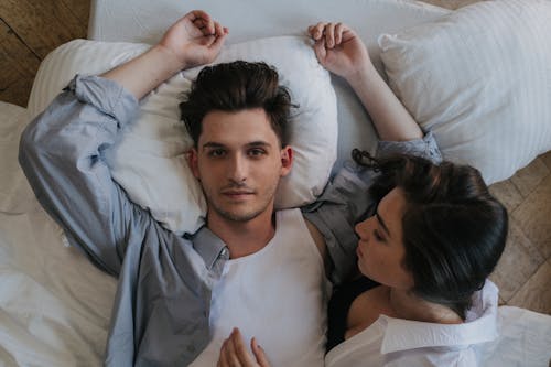 Woman Looking at a Man Lying on Bed