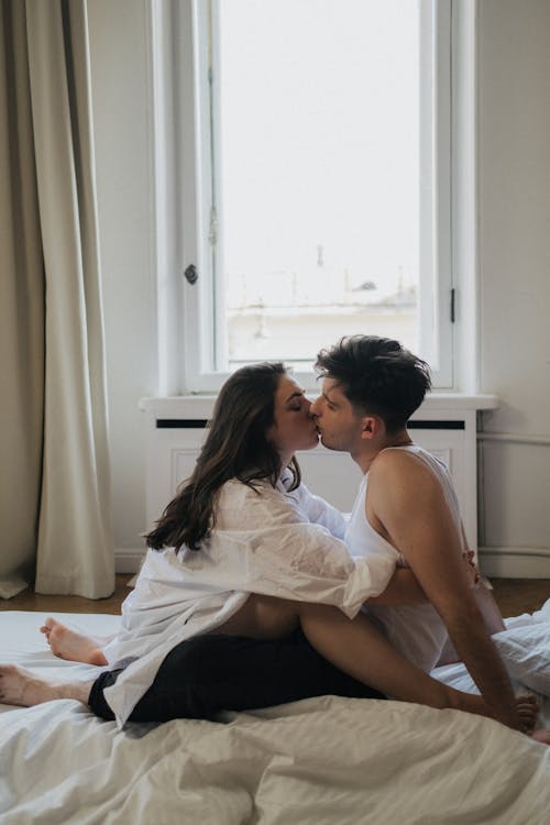 Free Man and Woman Sitting While Kissing  Stock Photo