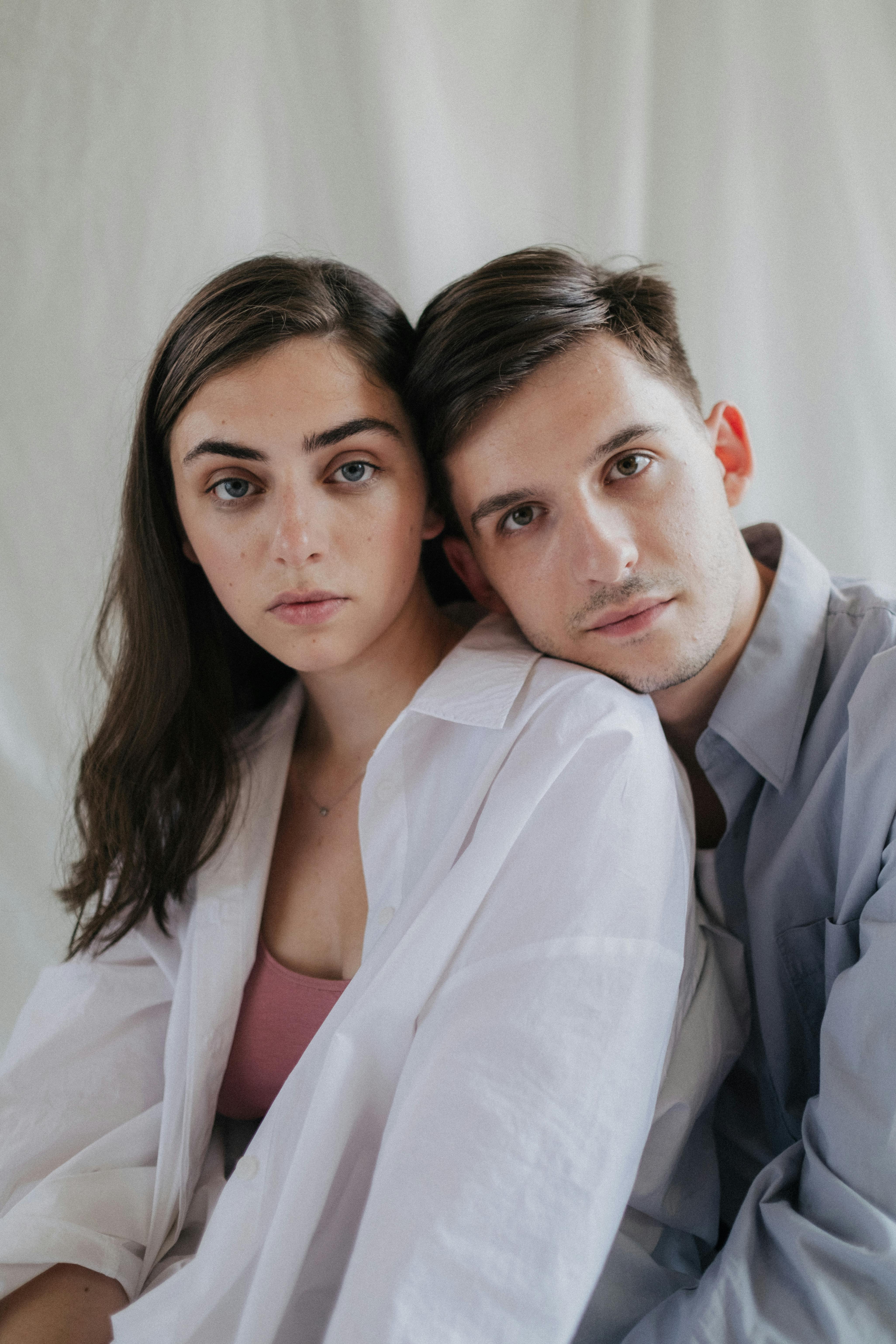 Close-up portrait of a young couple embracing indoors, showcasing affection and connection.