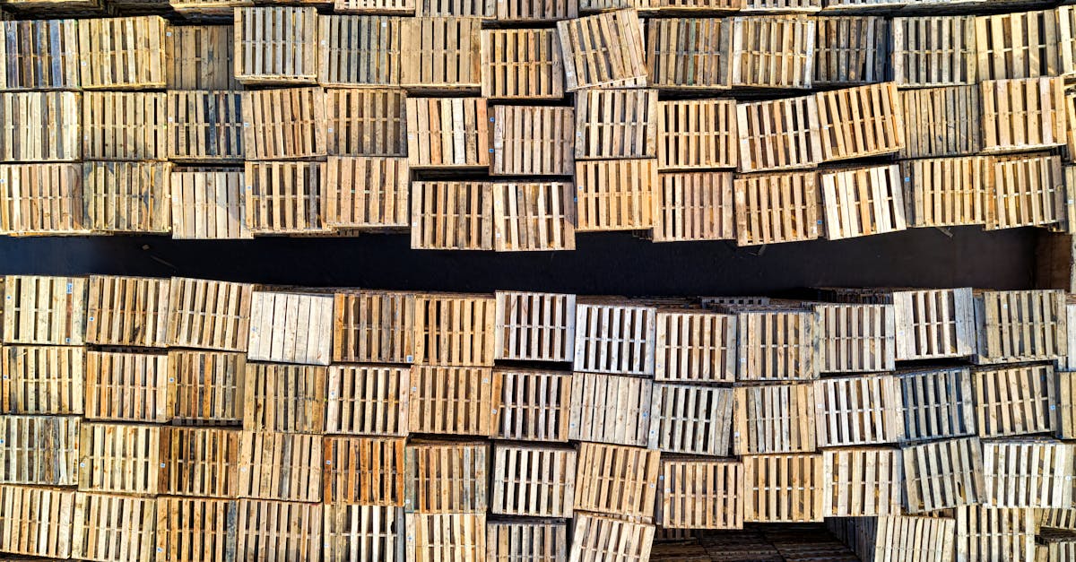 Wooden pallets being stacked in a warehouse.