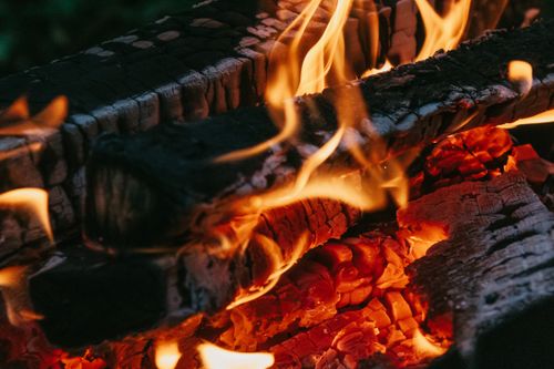 Free Intense close-up shot of burning wood with vivid flames and glowing embers. Stock Photo