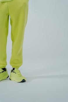 Close-up of neon sneakers paired with matching joggers in a studio setting.