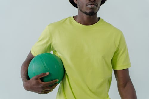 Man in Green Shirt Holding a Ball