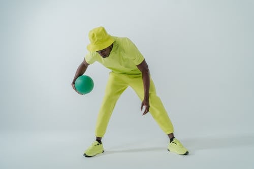 Man Wearing Green Clothing Dribbling a Ball