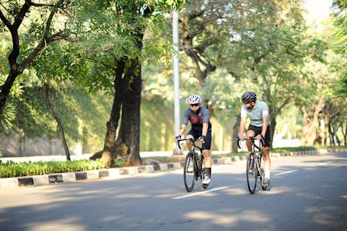 Free Men Riding Bicycles on the Street Stock Photo