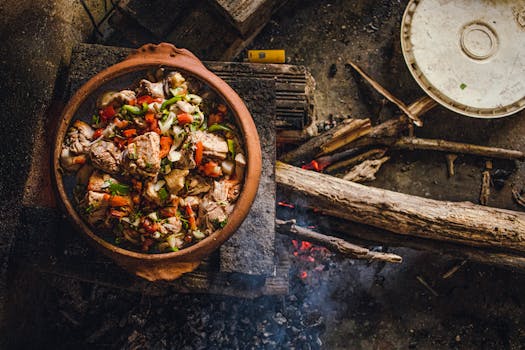 A rustic clay pot cooking meat and vegetables over an open wood fire in Brazil, showcasing traditional cuisine.