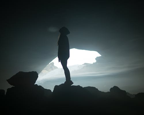 Free Silhouette of a Person Standing on a Rock Stock Photo