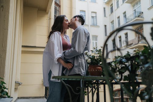 Free Couple Kissing on Balcony Stock Photo