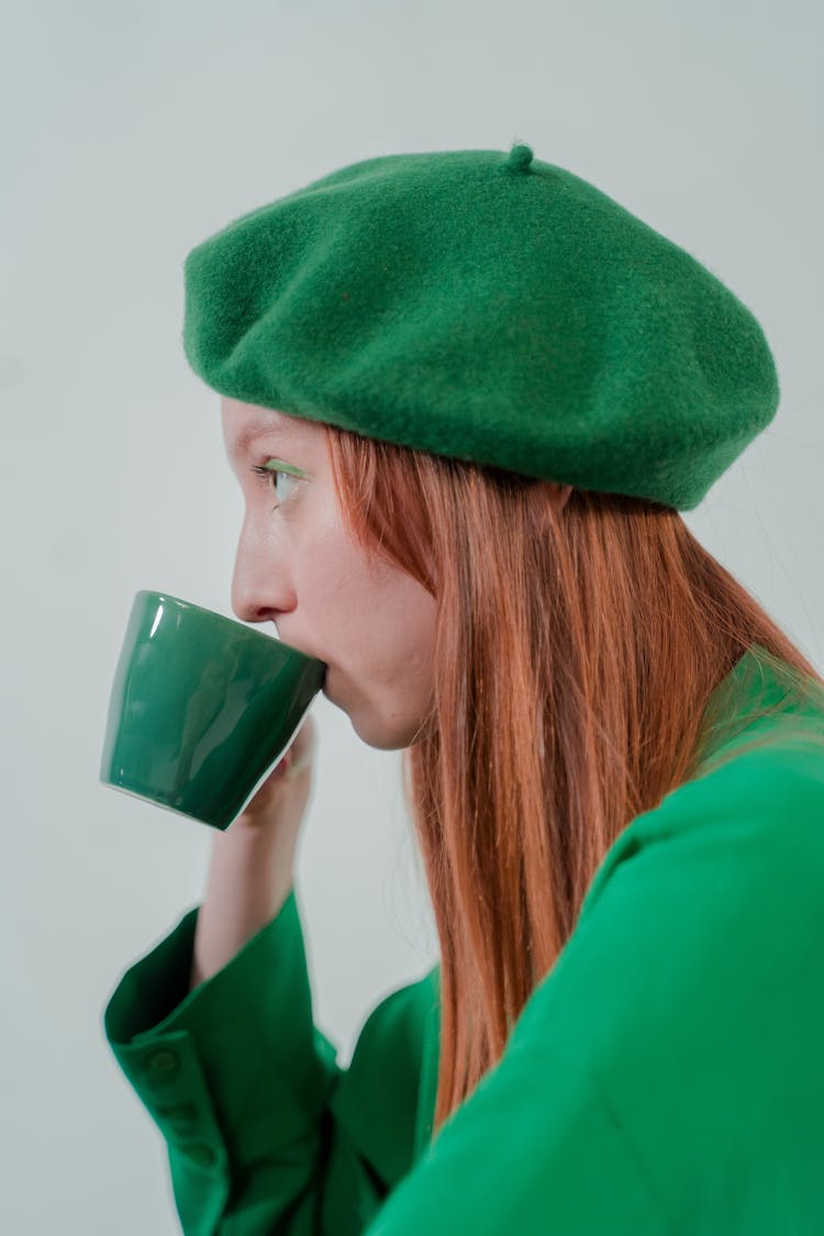 Woman In Green Long Sleeve And Hat Drinking On Mug 