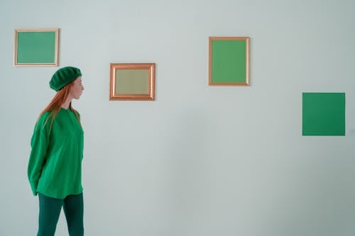 Woman Looking at Paintings in Art Gallery