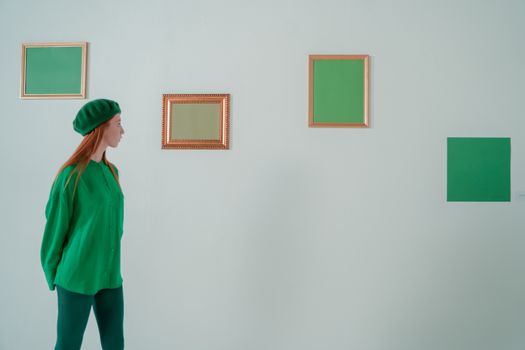 A woman in green attire viewing minimalist green paintings in an art gallery.