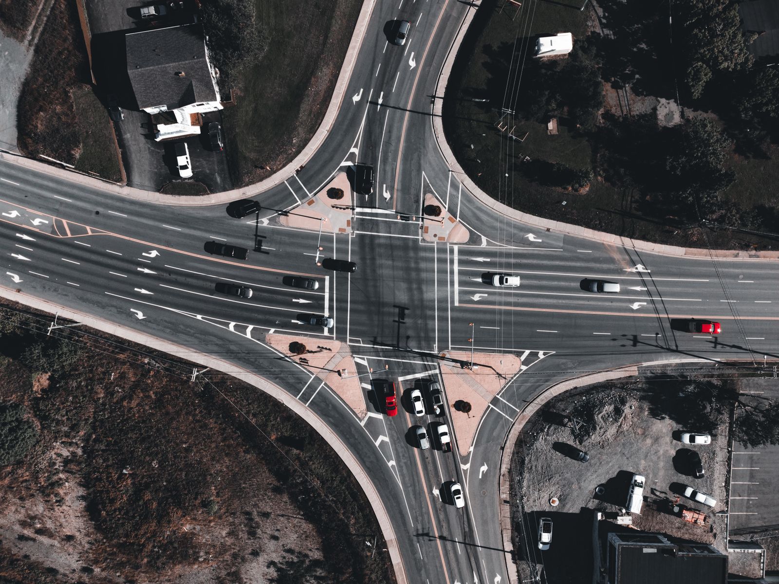 Aerial view of a multi-lane road intersection with vehicles splitting off in different directions