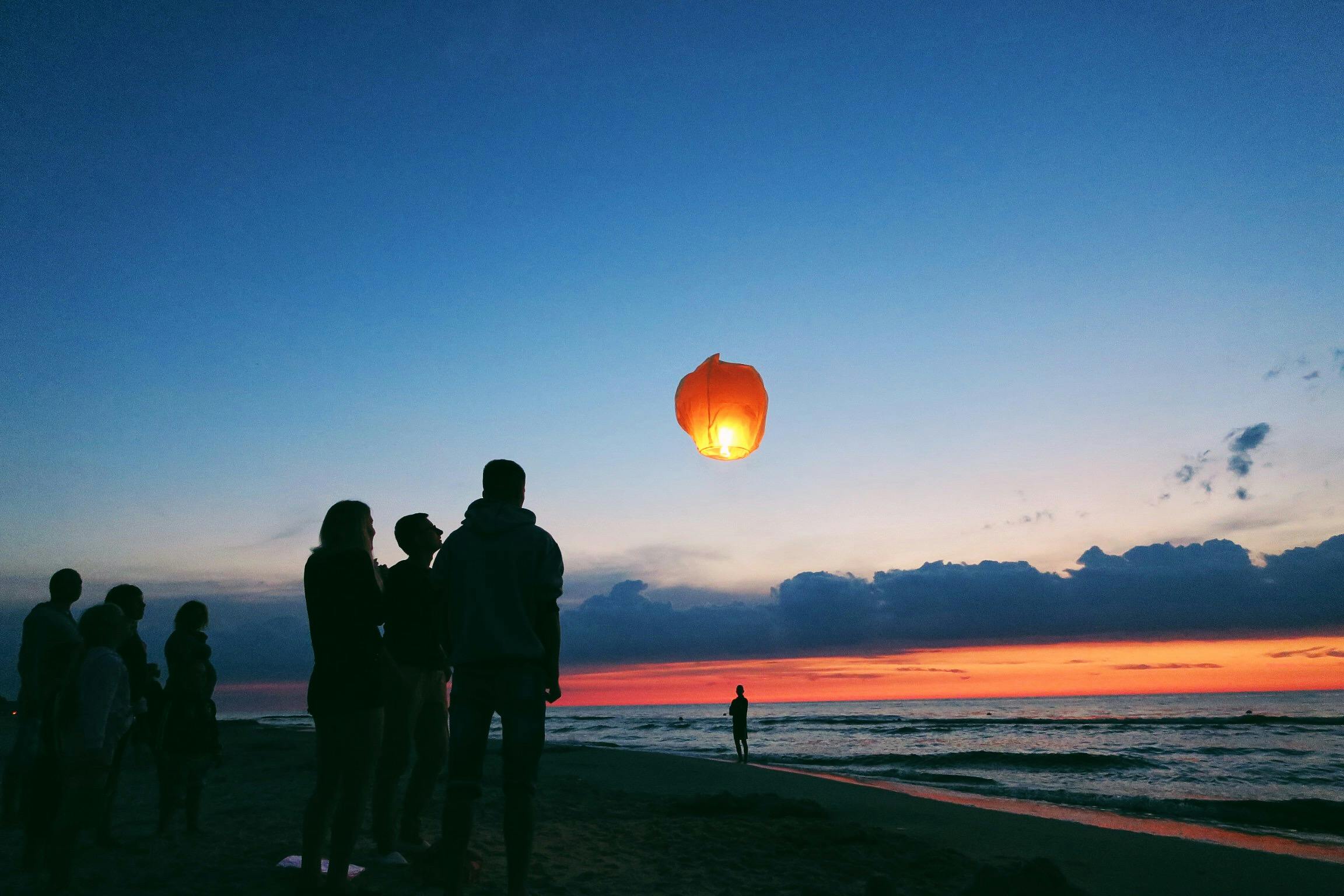 silhouette of people by the sea