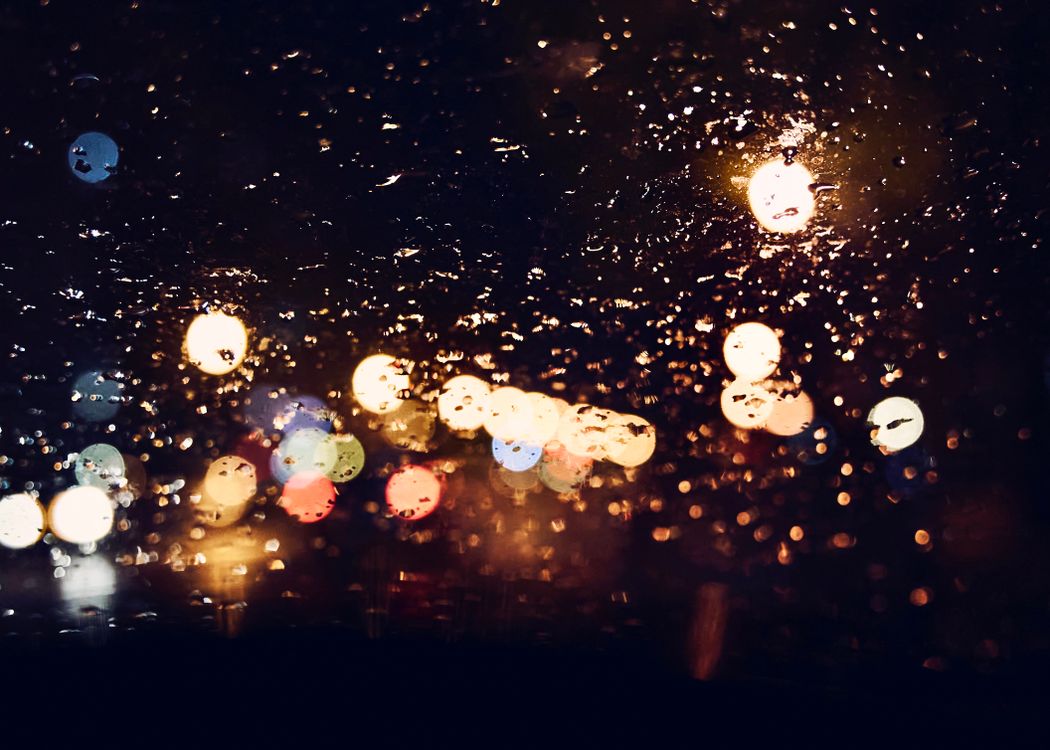 Blurry City Lights Behind a Rainy Window at Night · Free Stock Photo
