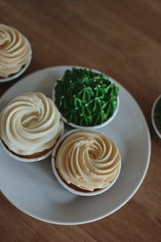 Close-up of assorted decorated cupcakes on a white plate.