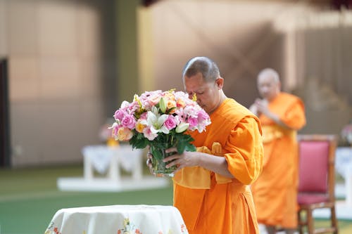 Free A Monk Offering a Bouquet of Flowers Stock Photo