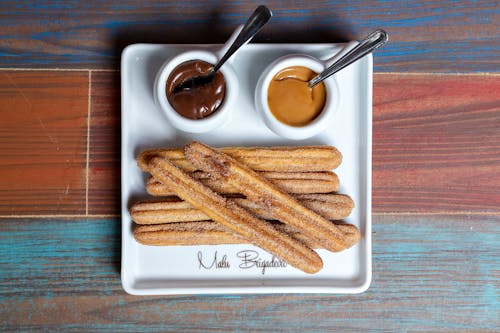 Top View of Churros and Dips on a White Plate