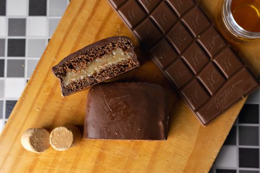 Top view of chocolate bars with filling on a wooden board, perfect for dessert lovers.