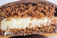 Macro shot of a chocolate-covered cake with creamy filling, showcasing texture and layers.